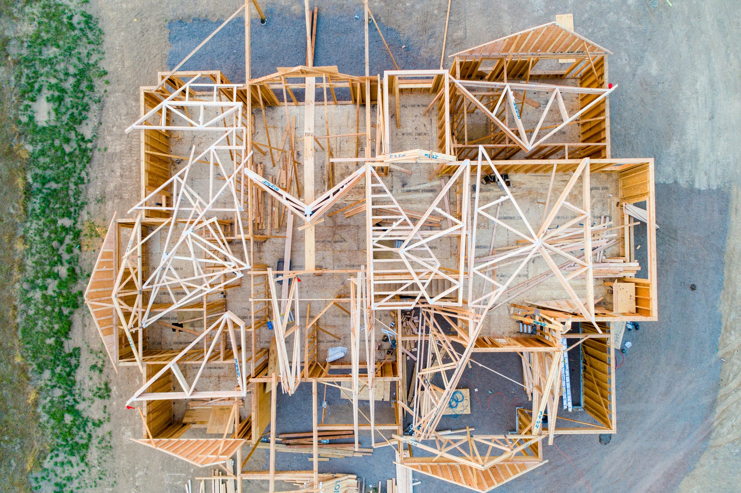 Wooden structure of a house being constructed, viewed from above